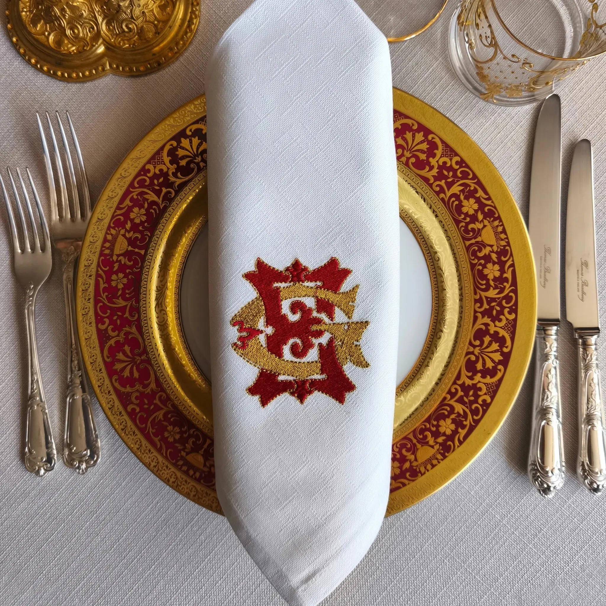 Embroidered linen dinner napkins with elegant monogrammed embroidery for fine dining table