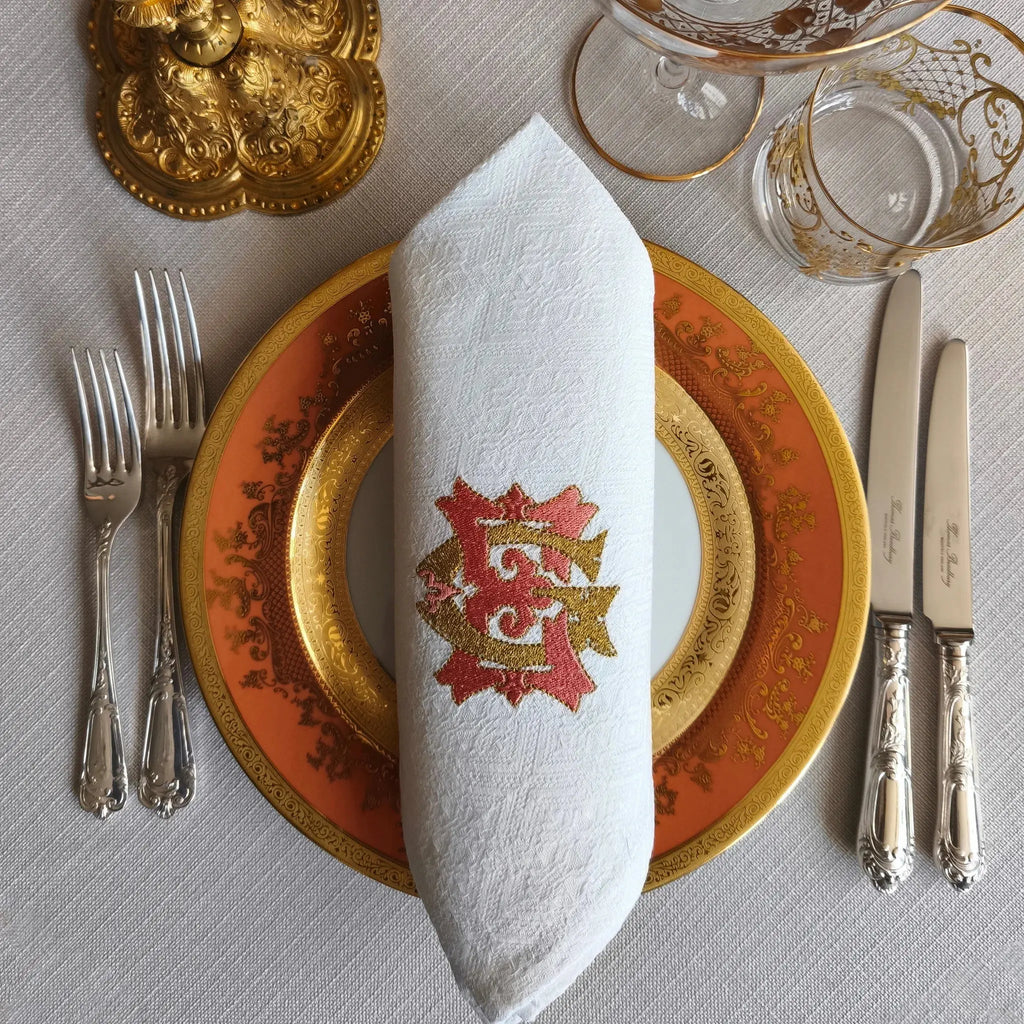 Embroidered linen dinner napkins with elegant monogrammed embroidery for fine dining table