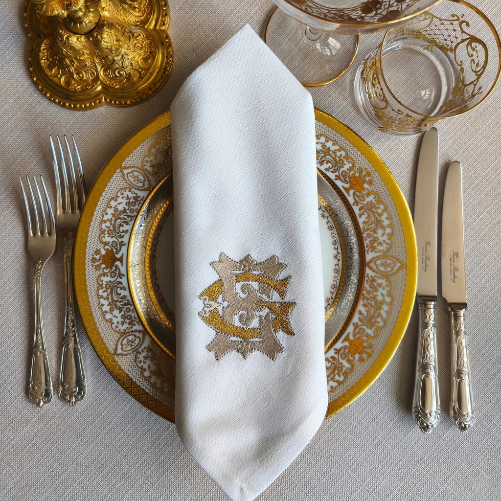 Embroidered linen dinner napkins with elegant monogrammed embroidery for fine dining table