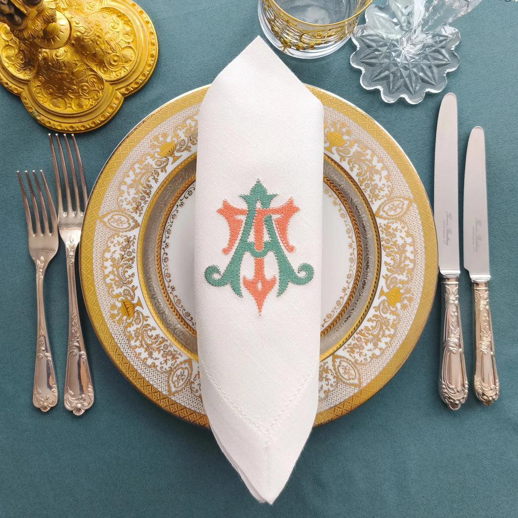Embroidered linen dinner napkins with elegant monogrammed embroidery for fine dining table