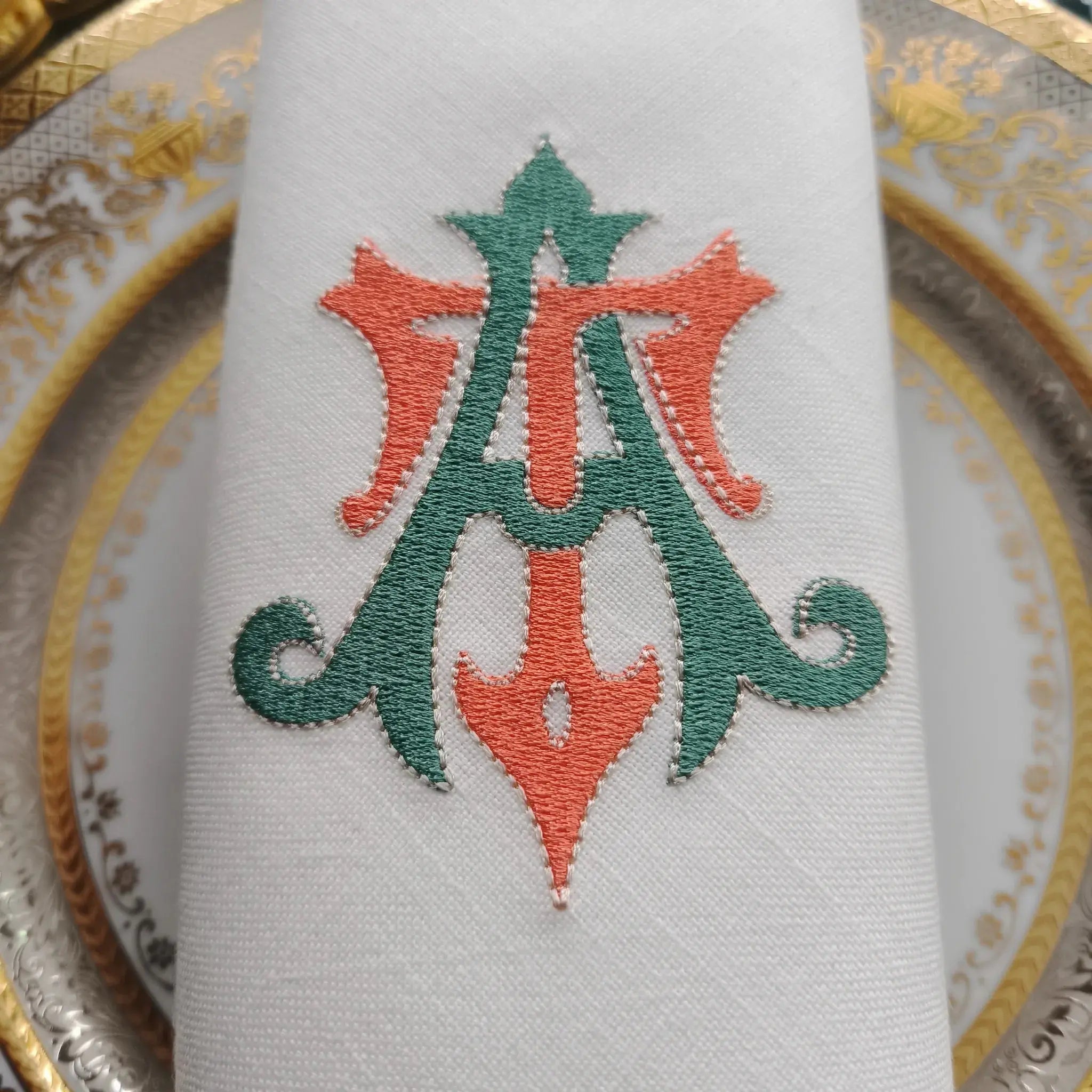 Embroidered linen dinner napkins with elegant monogrammed embroidery for fine dining table