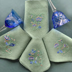 Embroidered linen dinner napkins with elegant monogrammed embroidery inspired by Versailles motive for fine dining table